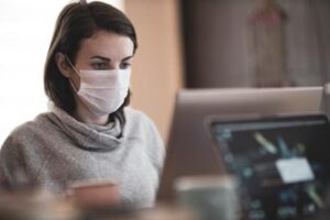 A female employee wearing a medical mask to work due to COVID-19.