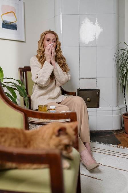 A woman sneezing because of carpet allergens