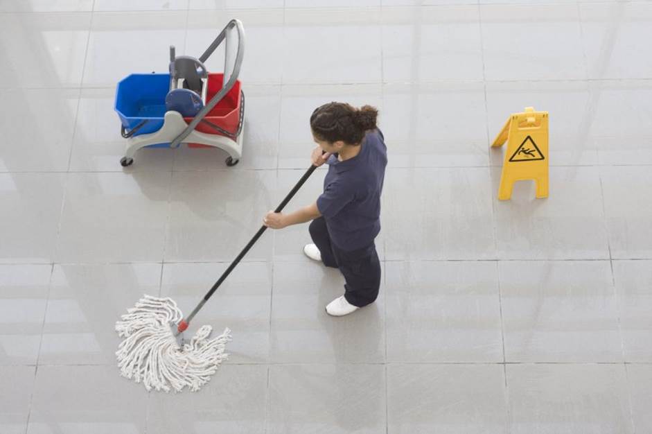 A professional cleaning company’s janitor cleaning the office floor