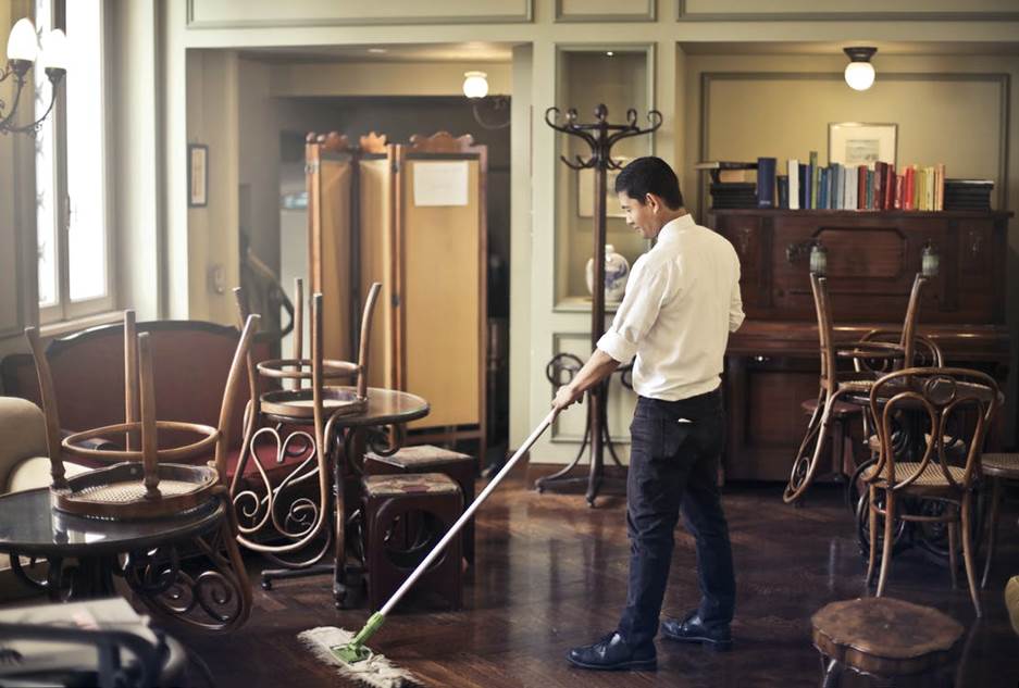 A person cleaning the area of the restaurant