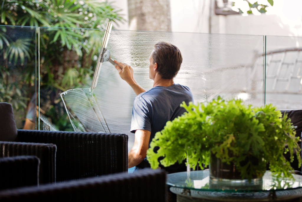 Office janitor wiping windows to clean it