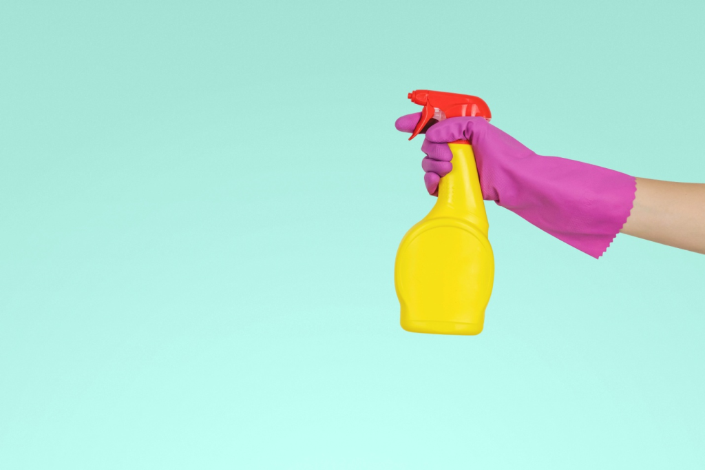 Spraying disinfectant using a spray bottle for commercial cleaning in Kansas City