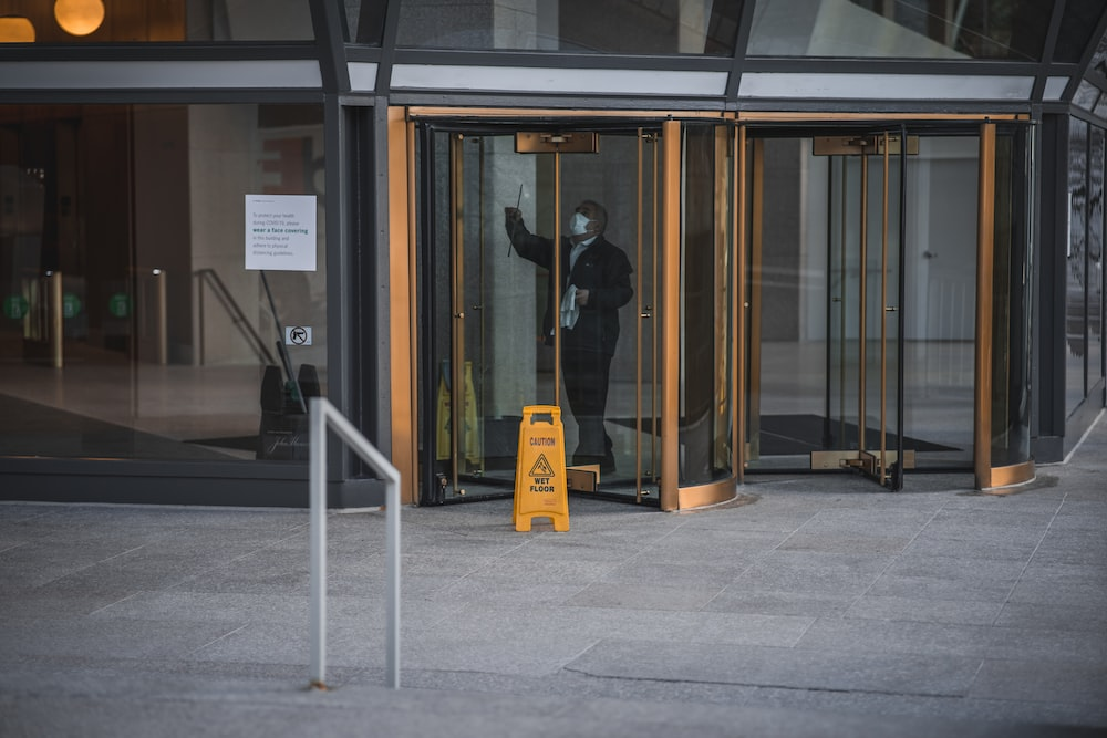 A person cleaning a glass door.