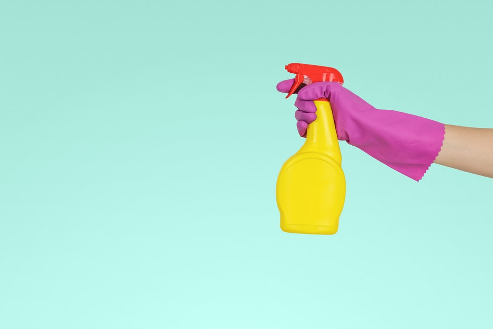 Person spraying a chemical cleaner