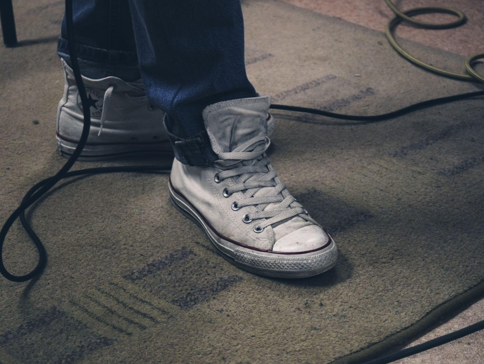 An individual wearing shoes on a carpet 