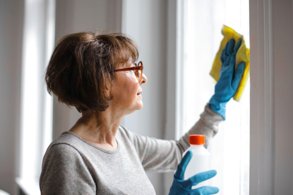 A woman cleaning her windows in winter