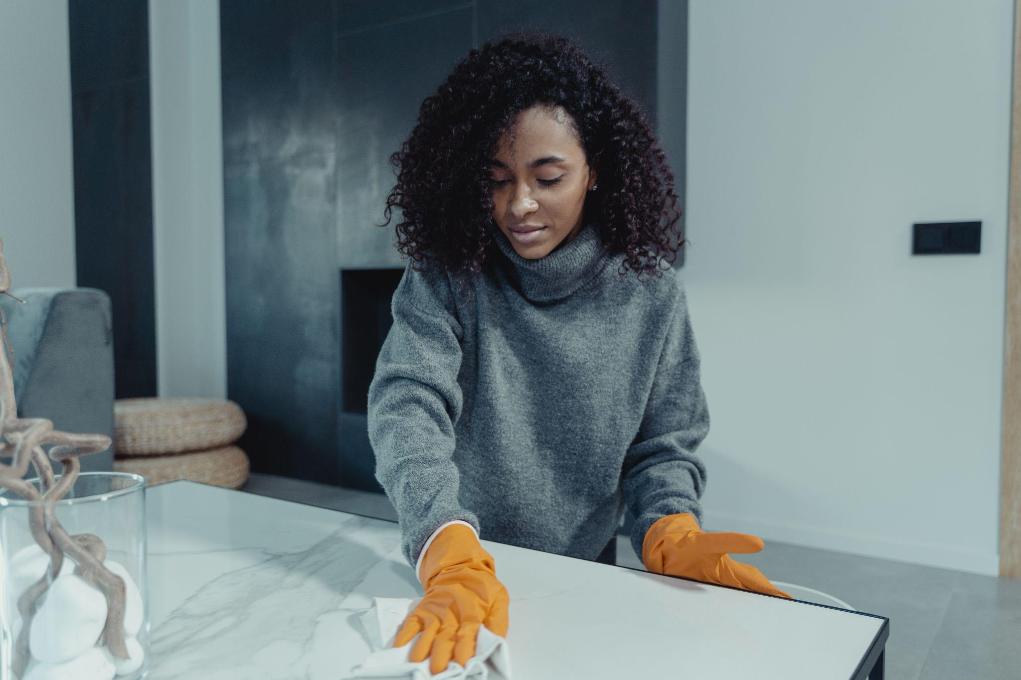 A woman wiping down the countertop before moving out