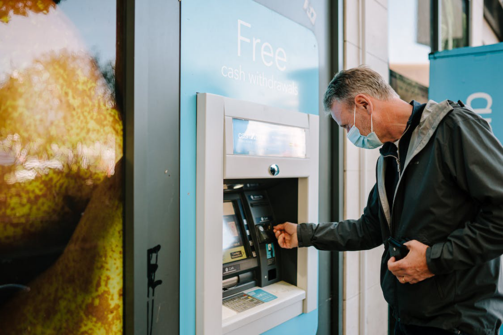 A man using an ATM machine in a bank