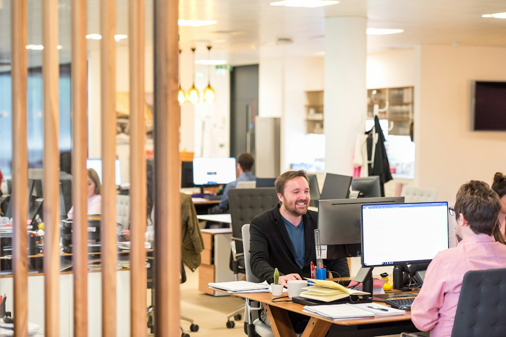 A happy employee sitting at a desk in an office