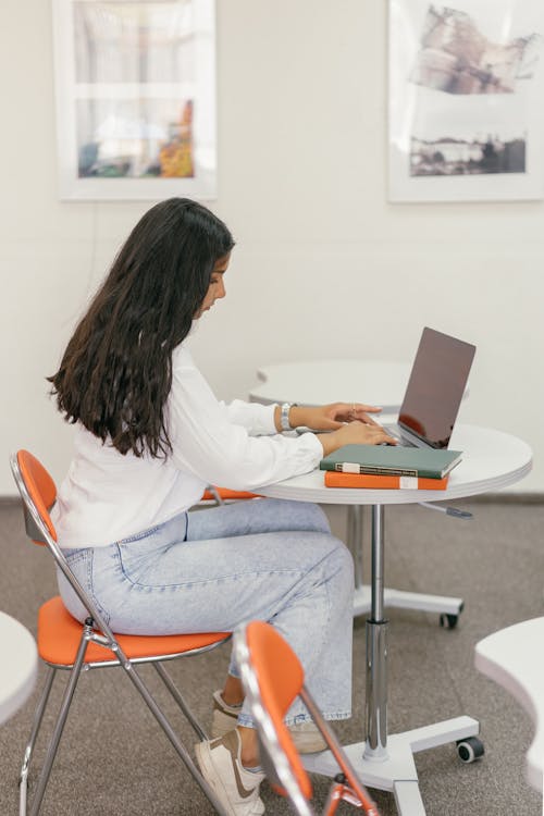 A female student in a white long-sleeve shirt sitting at a desk.