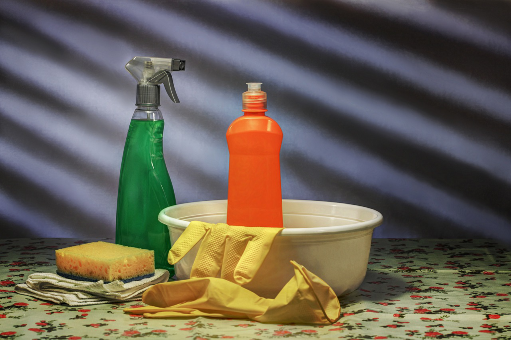 different bottles next to rubber gloves and sponge
