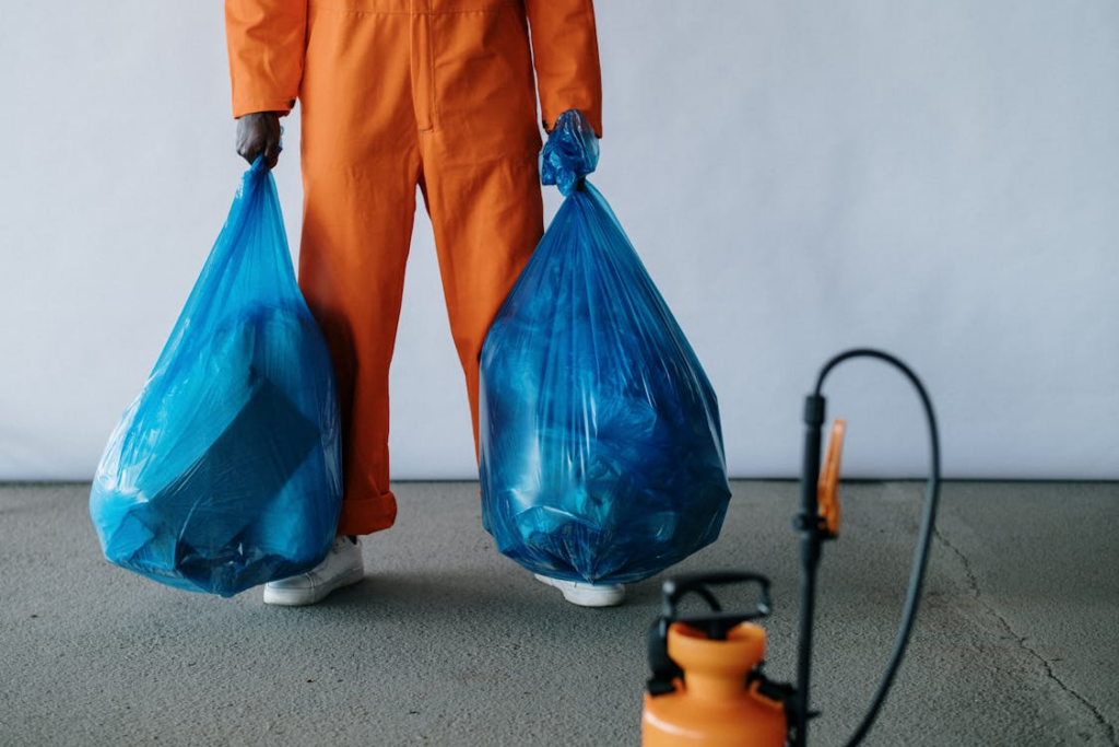 Man in work attire disposing of trash in a plastic bag