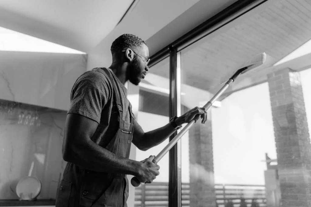 A cleaning professional deep cleaning an office window.
