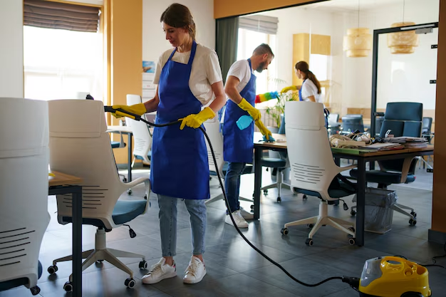 Janitorial staff members cleaning an office with professional tools in Kansas City.