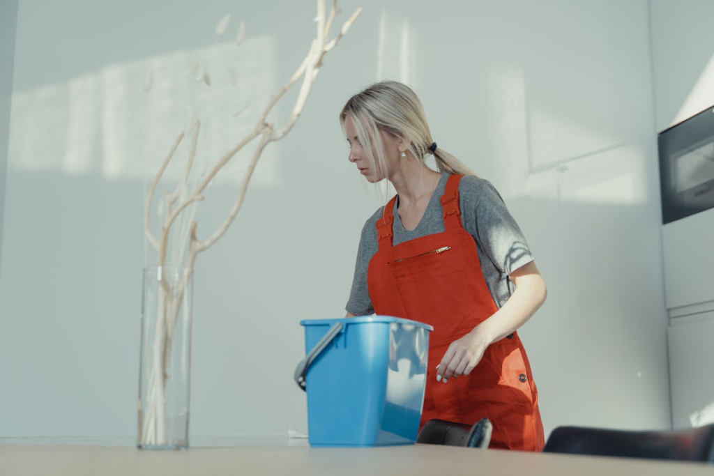 An image of a person wearing orange overalls while cleaning