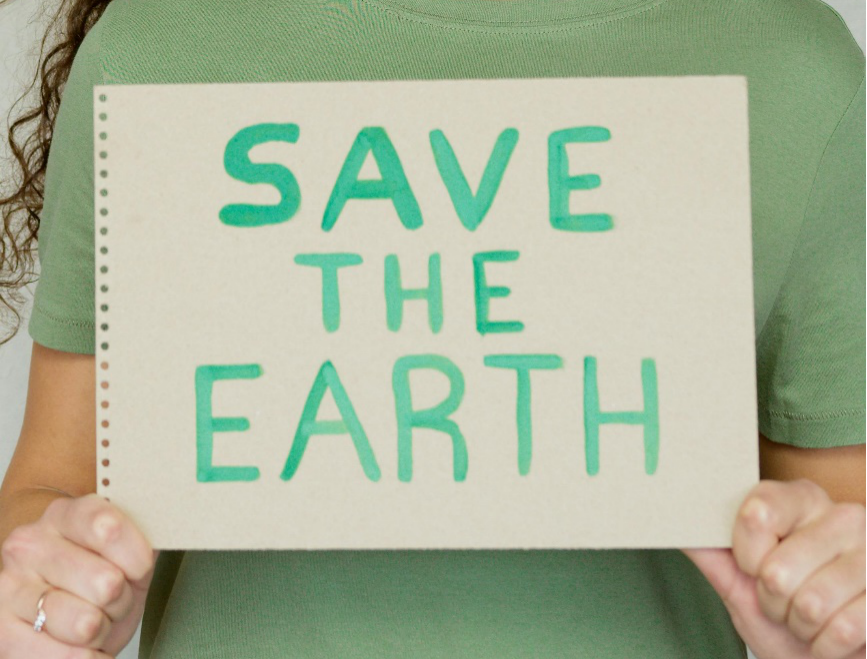 Person holding a placard saying ‘save the earth’.