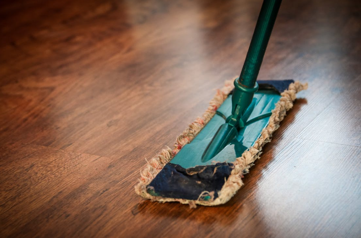 A mop cleaning a wooden floor.