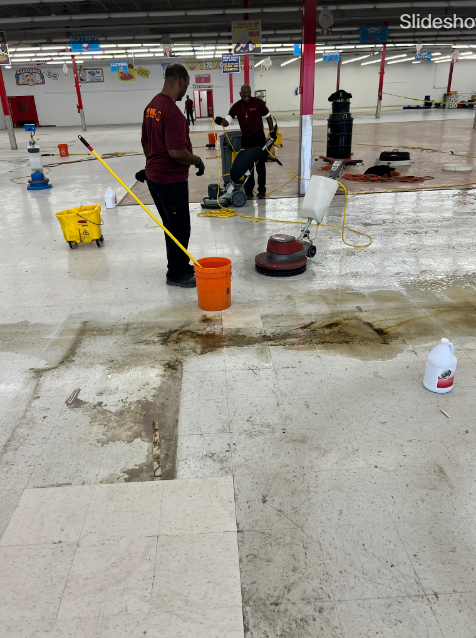 Workers cleaning a large, tiled floor with various cleaning machines