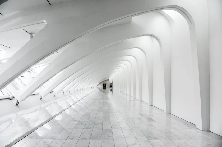 A long, white hallway with a light gray tiled floor
