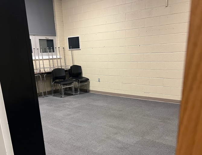 Waiting room with chairs stacked for cleaning on a carpeted floor.