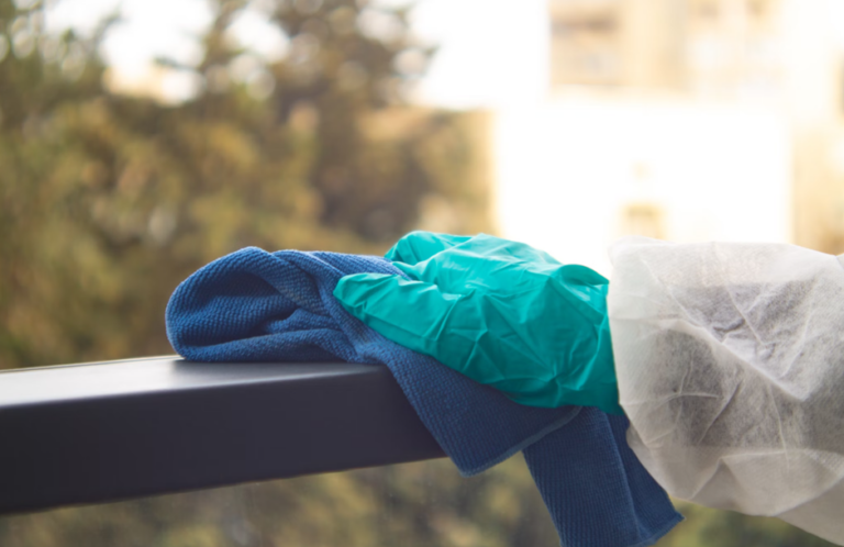 Person disinfecting a railing.