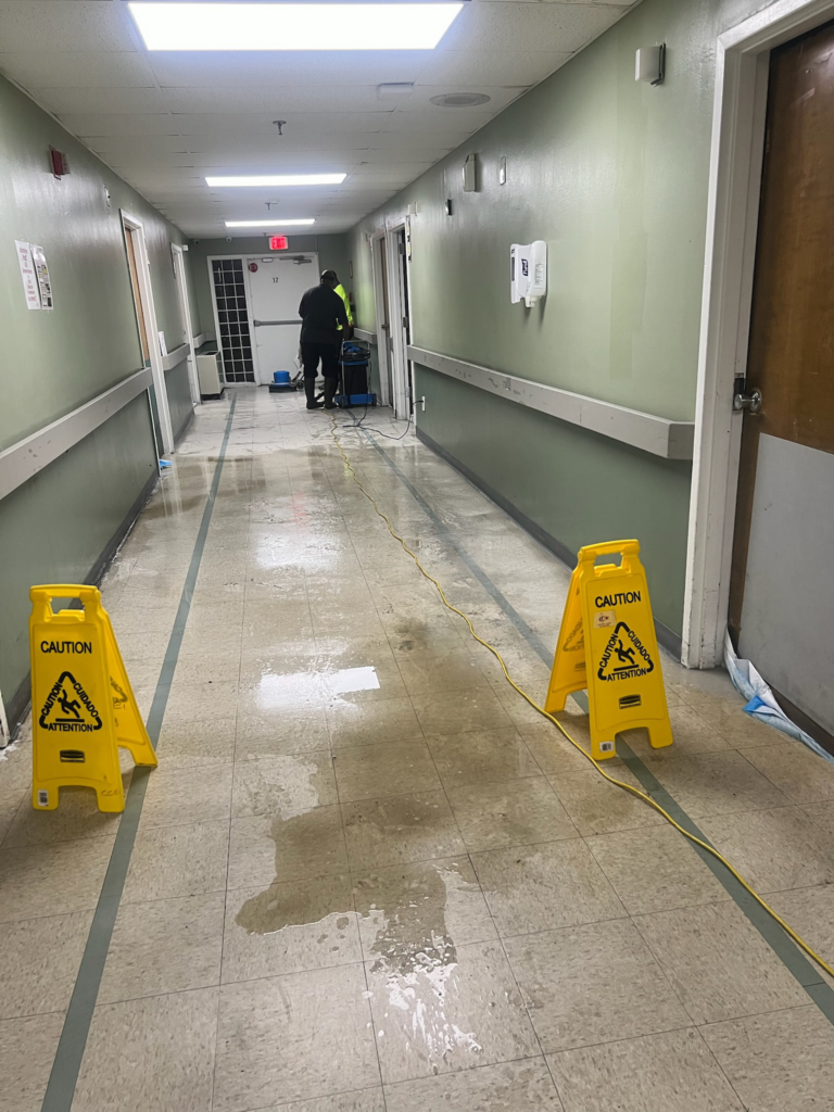 a corridor getting cleaned, with dirt collecting at one end