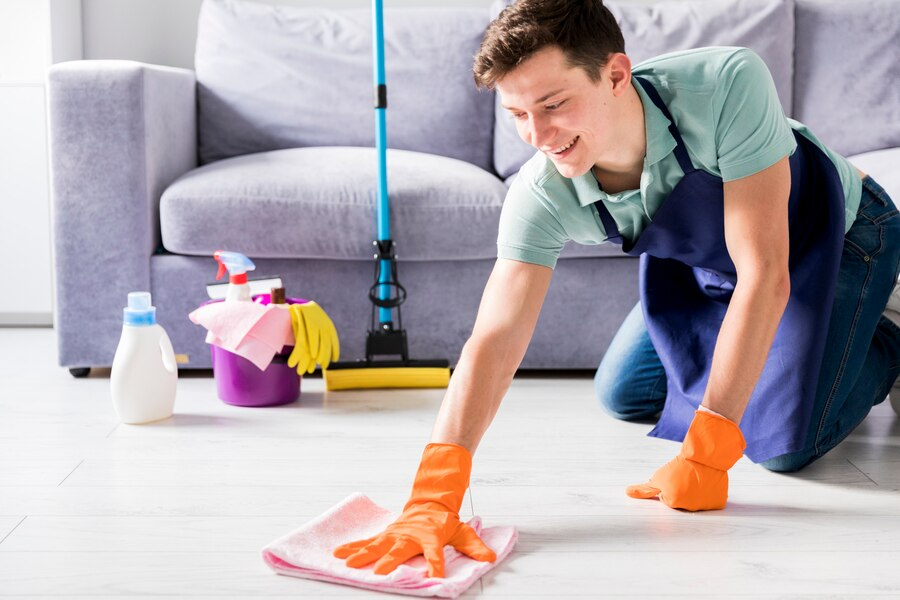 A professional wiping the floor with a cloth.