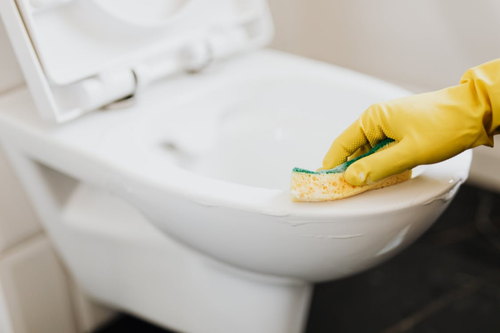 Disinfecting toilet surfaces to maintain student health.