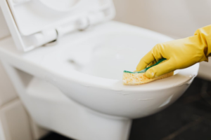 Disinfecting toilet surfaces to maintain student health.