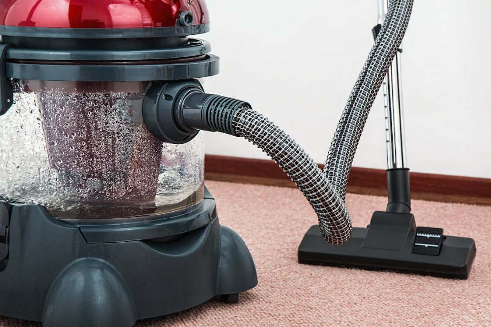 Close-up of vacuum cleaner removing dirt from carpet surface