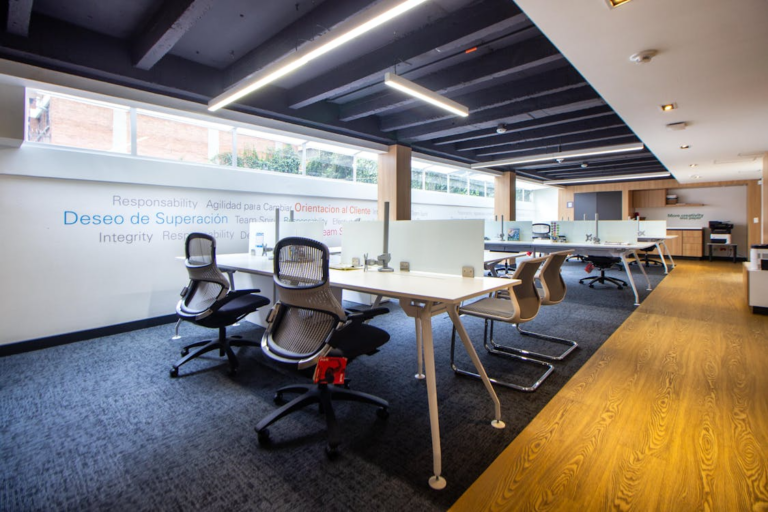 Modern office workspace with clean carpet, desks, and ergonomic chairs