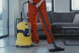 Cleaning professional using vacuum cleaner on office floor in modern interior